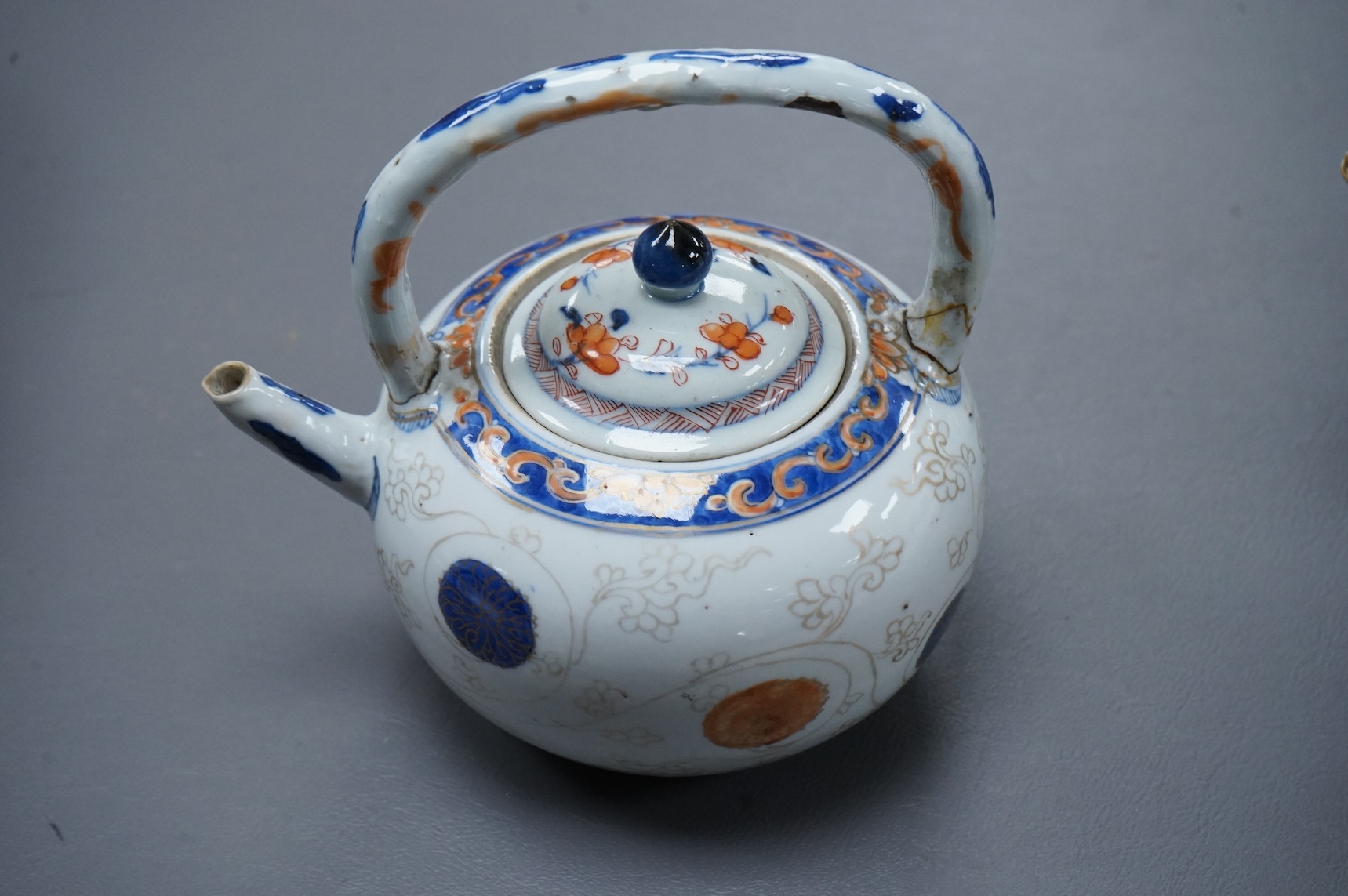A Chinese famille rose ‘boys and ladies’ teapot, Qianlong period and a Japanese Arita sake pot or ewer, early 18th century, tallest 16cm high.